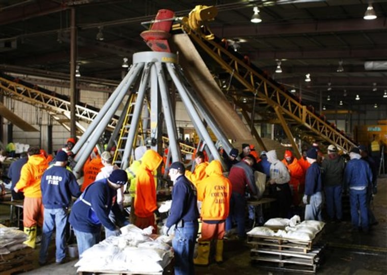 Cass County inmates, city employees and volunteers man an "Octopus" sandbagging machine in Fargo, N.D., on March 1.